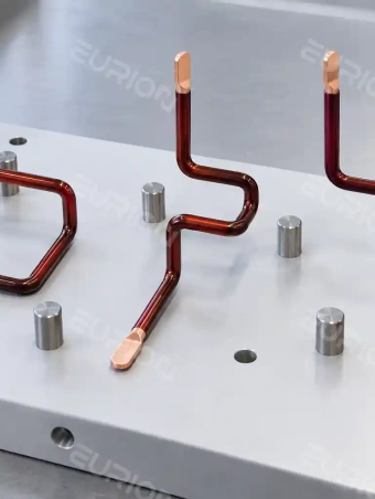 Three-phase motor stator lead wires positioned on an inspection fixture